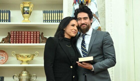 Tulsi Gabbard and her husband, Abraham Williams, hug before she is sworn in as Director of National Intelligence in the Oval Office of the White House in Washington, D.C., on Feb. 12, 2025.