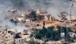 This picture taken from a position in the Upper Galilee in northern Israel, near the Israel-Lebanon border, shows Israeli Merkava tanks driving along a road past destroyed buildings in southern Lebanon on June 17, 2026.
