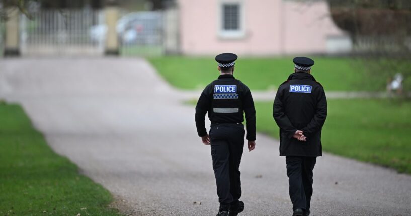 Police officers approach the gates of the Royal Lodge, Andrew Mountbatten-Windsor's former residence in Windsor Great Park, on Feb. 20, 2026, in Windsor, England.