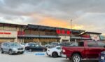 The view from parking lots to the store entrance of a recently opened H-E-B Grocery Company franchise supermarket chain with busy traffic at sunset in Plano, Texas, on July 8, 2023.