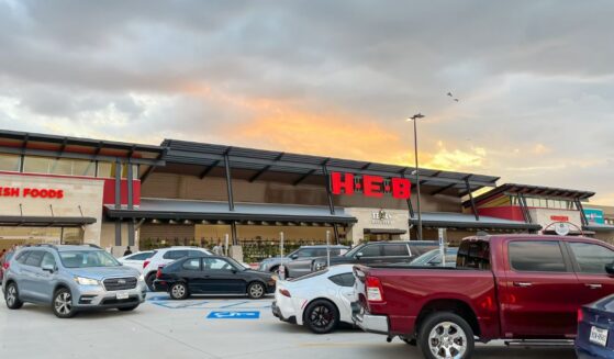 The view from parking lots to the store entrance of a recently opened H-E-B Grocery Company franchise supermarket chain with busy traffic at sunset in Plano, Texas, on July 8, 2023.