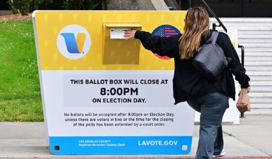 A voter drops a ballot in a drop box Monday at the Los Angeles County Registrar during early voting in the state's primary election.