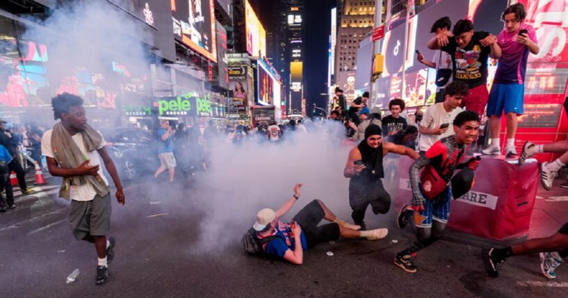 New York Knicks fans run from fireworks in Times Square during Game 4 of the NBA Finals between New York Knicks and San Antonio Spurs, on Tuesday in New York City.