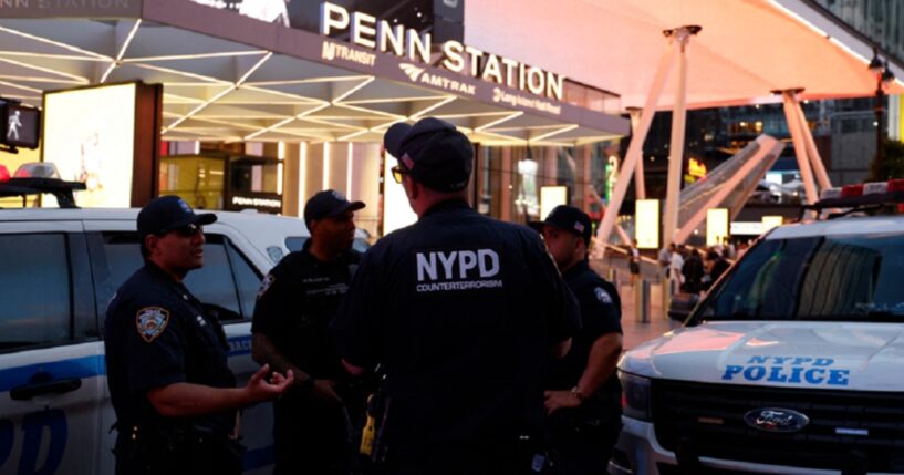 New York City police officers gather outside Penn Station on Sunday after a stabbling that left five wounded.