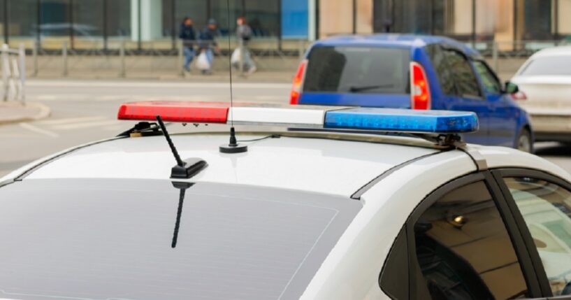 A police car with flashing lights is pictured in a stock photo. 