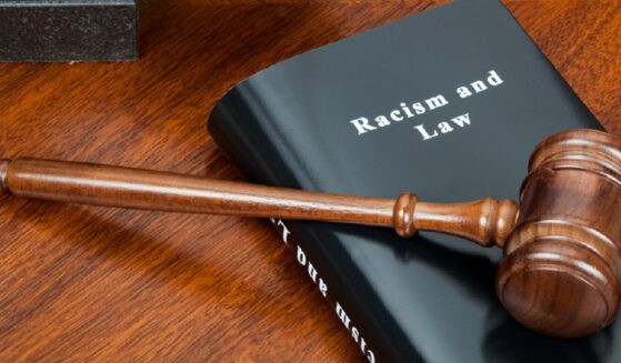 A gavel over a book tiled "Racism and Law."