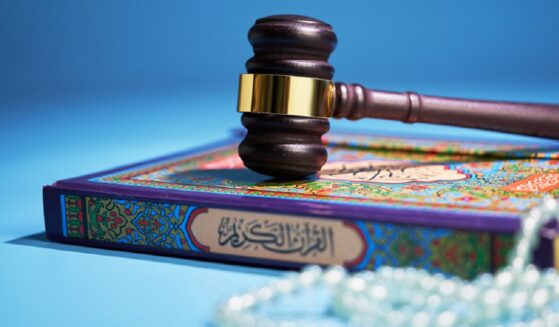 A gavel sits atop a Quran and Islamic prayer beads in a photo illustration.