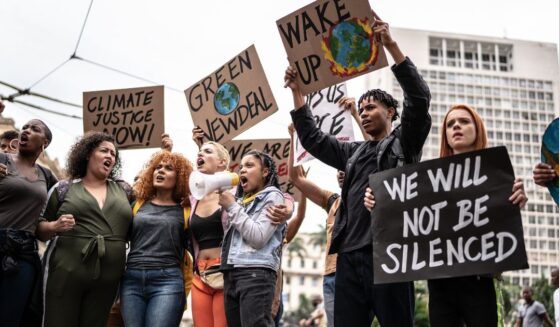 Protesters holding signs during a demonstration for environmentalism.