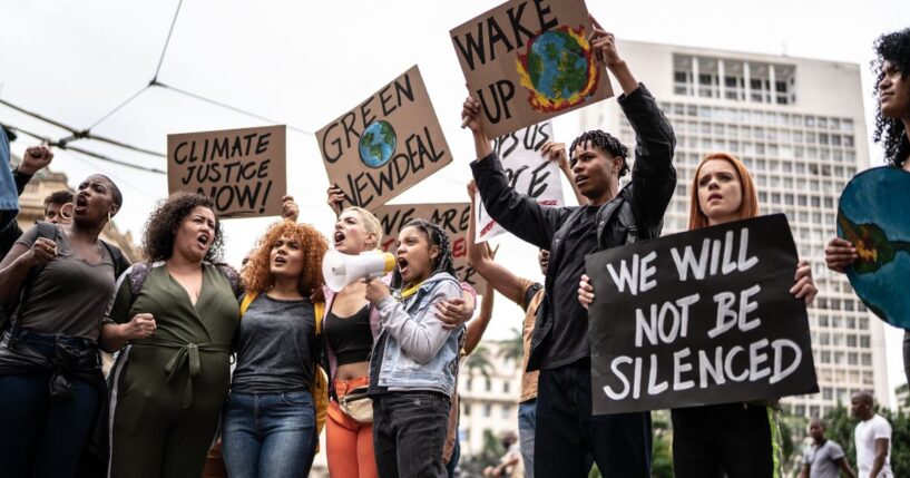 Protesters holding signs during a demonstration for environmentalism.
