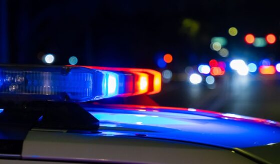 A crime scene in a city at night with blue and red police lights.