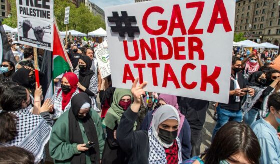 Demonstrators hold signs as thousands gather during a rally to support Palestine at Copley Square in Boston, Massachusetts, on May 15, 2021.