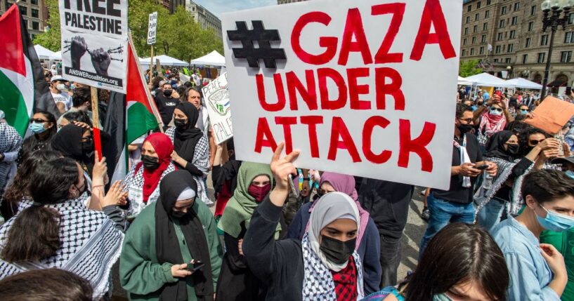 Demonstrators hold signs as thousands gather during a rally to support Palestine at Copley Square in Boston, Massachusetts, on May 15, 2021.