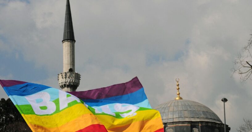 Turkish activists wave flags in front of a mosque in Istanbul on March 16, 2010, during a demonstration against Family Affairs Minister Aliye Selma Kavaf.