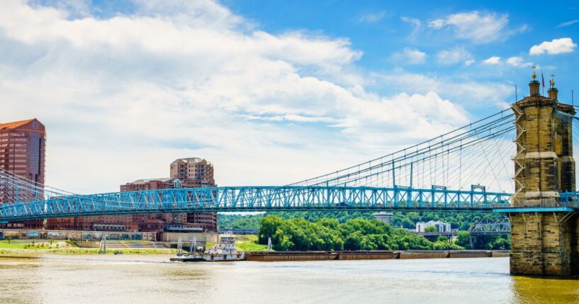 Barges are going under the Roebling Bridge in Cincinnati, Ohio.