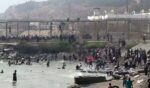 This video frame grab obtained from an AFP video shows migrants reaching the shore of Spanish north African exclave of Ceuta, after swimming around the border fence between Morocco and Spain, in Ceuta on July 30, 2026.