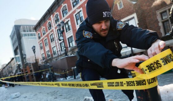 Police put up crime scene tape as members of the Hasidic Jewish community gather outside of the Chabad Lubavitch world headquarters, where a man was arrested Wednesday evening after repeatedly crashing his car into a door of the building on Jan. 29, 2026, in New York City.