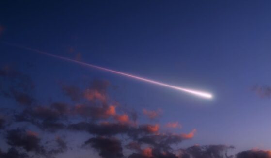 A bright shooting star above the clouds.