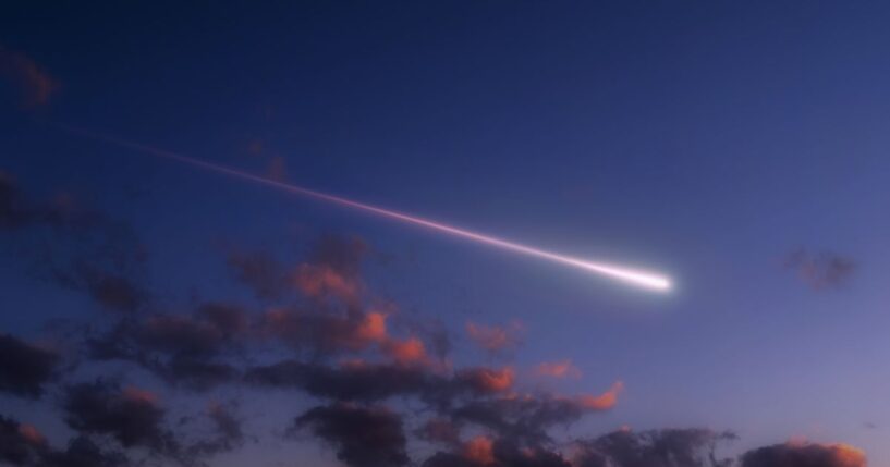 A bright shooting star above the clouds.