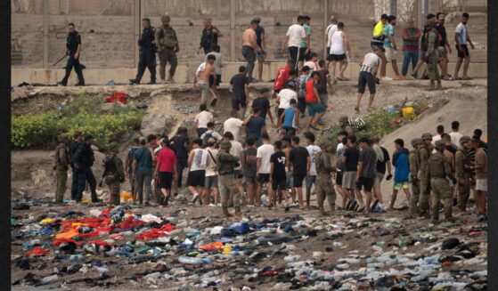 Spanish soldiers direct migrants back to Morocco after they crossed the border to enter Spain's north Africa's Ceuta territory on Thursday. In recent days, a total of around 60,000 migrants have crossed into the territory, whose population is 80,000.