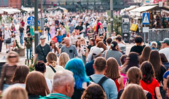 People walk on a busy street during the day.