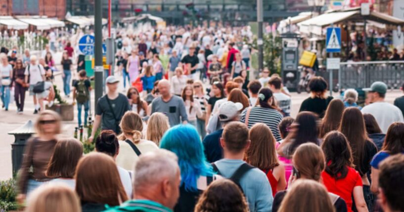 People walk on a busy street during the day.