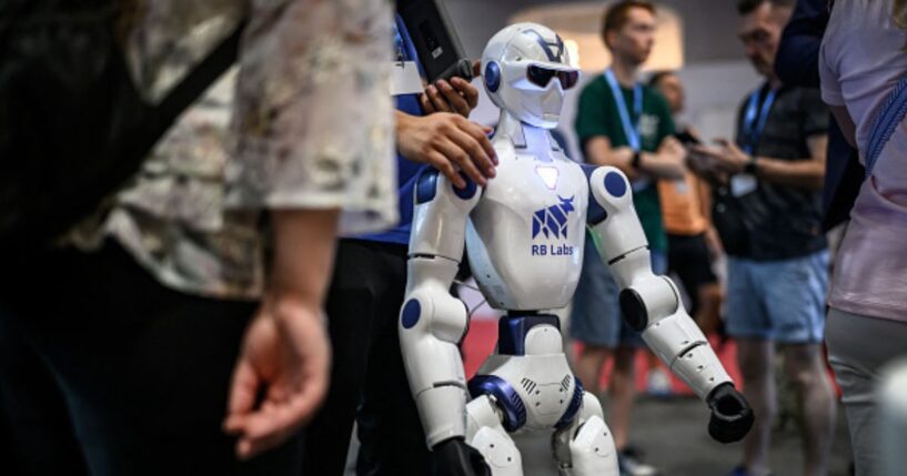 A robot stands amongst a crowd at the AI for Good Global Summit on July 7, 2026.