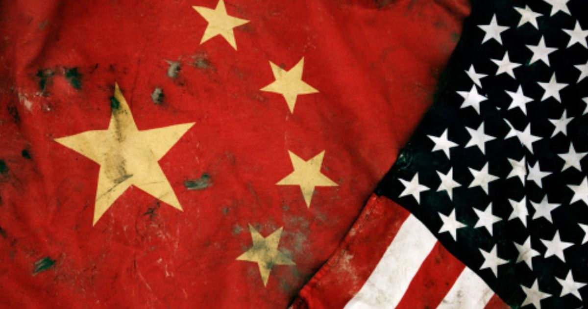 Grungy Chinese and American flags lay near each other.