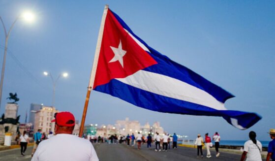 A man walks with a Cuban flag alongside the Havana waterfront on May 1, 2026.