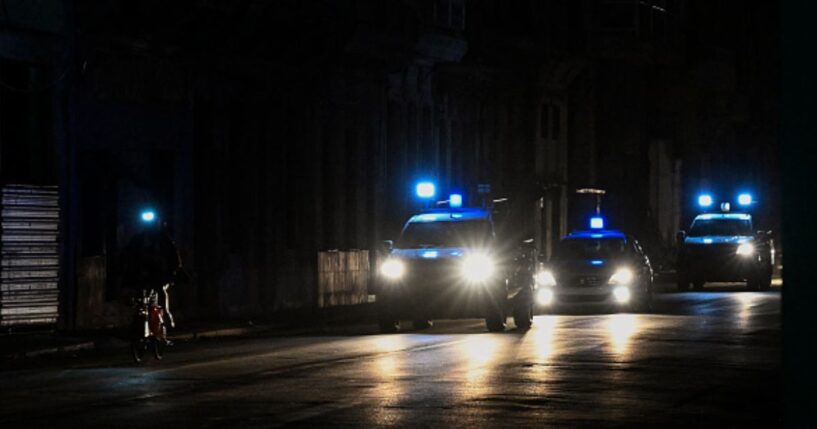 Police lights flash on a dark road in Havana on March 21, 2026.