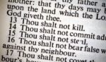A photo of the Ten Commandments on a lit piece of paper is pictured.