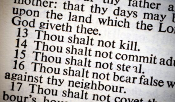 A photo of the Ten Commandments on a lit piece of paper is pictured.