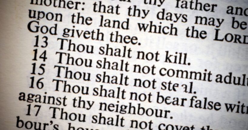 A photo of the Ten Commandments on a lit piece of paper is pictured.