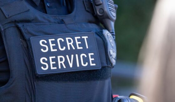 A Secret Service agent displays the text on his black vest.