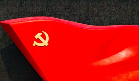 An object depicting a hammer and sickle icon on the edge is pictured ahead of a black surface.