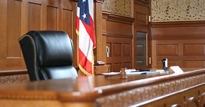 A wooden courtroom sits empty.