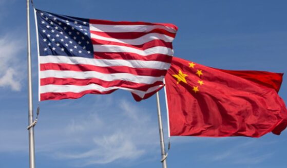 An American flag and Chinese flag wave in strong winds during the afternoon.