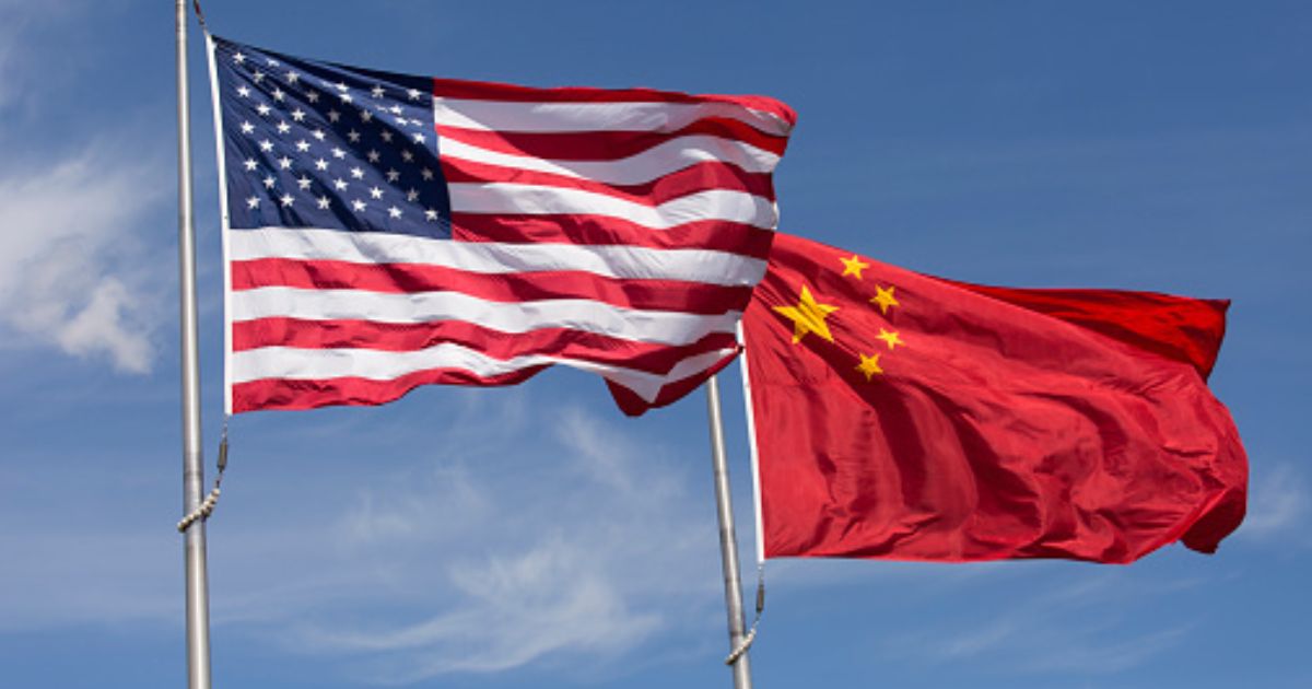 An American flag and Chinese flag wave in strong winds during the afternoon.