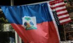 An American and Haitian flag hang on a bar outside a shop on June 25, 2026.