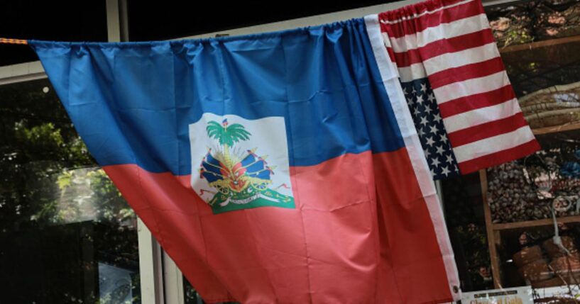 An American and Haitian flag hang on a bar outside a shop on June 25, 2026.