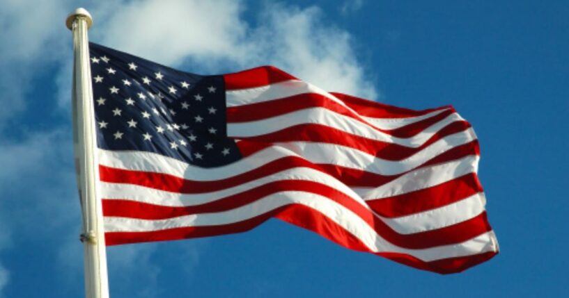 The American flag waves in the wind on a bright afternoon.