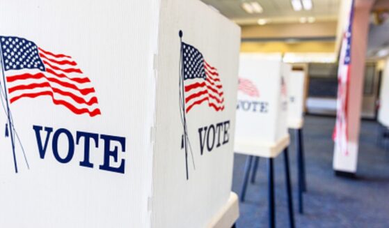 Rows of empty voting booths fill a bright civic center.