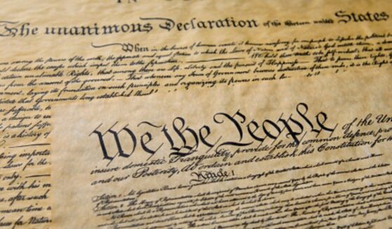 Pages of the Constitution are visible under warm lighting.