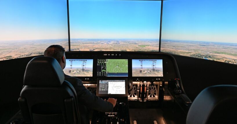 A man sits inside the cockpit of a flight simulator for the Overture Supersonic Airliner at the Boom Supersonic exhibition hall at Farnborough International Exhibition in Farnborough, England, on July 23, 2024.