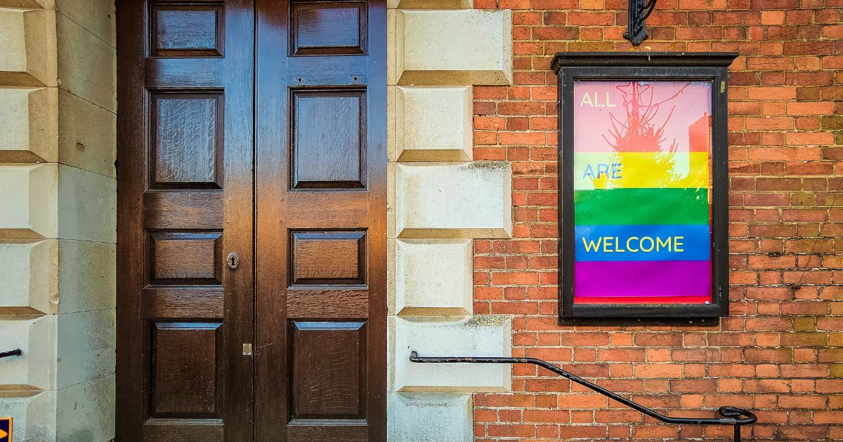 An LGBT-affirming sign posted outside the front door to a Christian church.