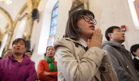 A woman prays in a packed Cathedral in Beijing, China on March 24, 2016.