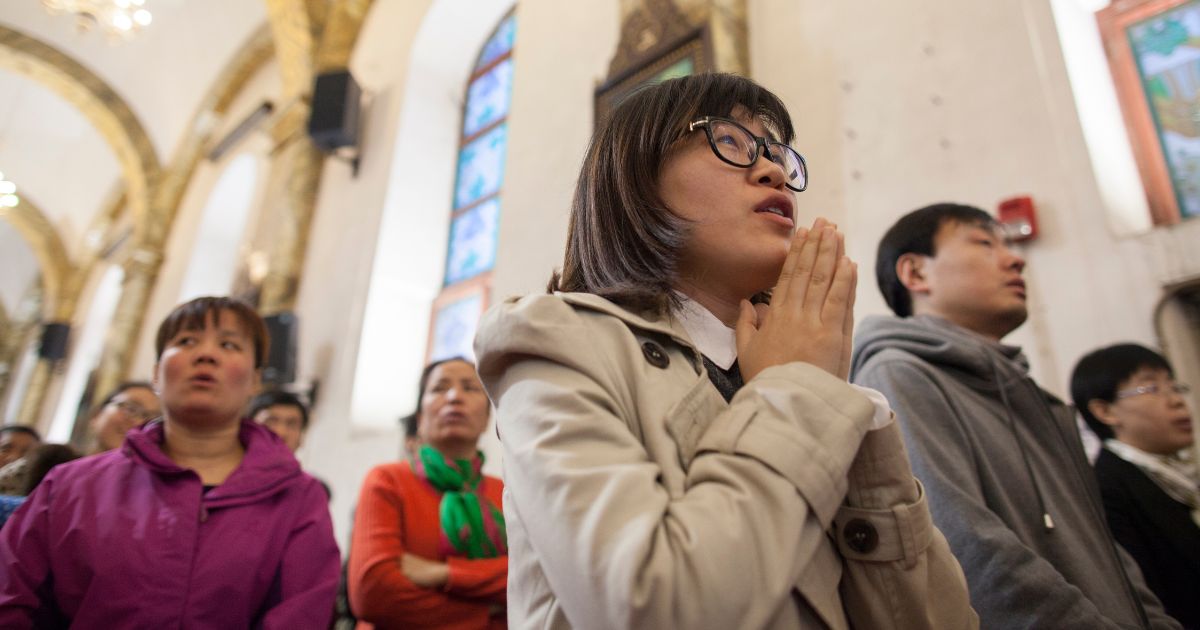 A woman prays in a packed Cathedral in Beijing, China on March 24, 2016.