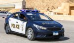 An Egyptian police car sits on a road.