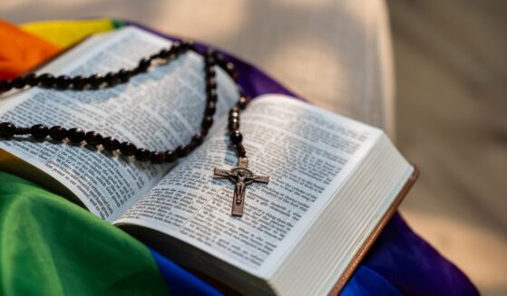 A Holy Bible sitting on top of a rainbow flag.