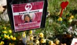 Flowers and signs are seen in a makeshift memorial in front of the home of Nancy Guthrie on Feb. 27 in Tucson, Arizona. Guthrie went missing from her home on the morning of Feb. 1.