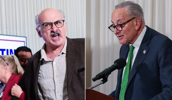 A protester identified as Sam Husseini, left, was escorted out of a news conference where Sen. Chuck Schumer, right, a New York Democrat, was trying to speak.